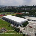 Aerial view of large TFS curve structure tennis court marquee covering eight outdoor courts