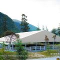 30m x 35m equestrian arena marquee on a sloped lawn, mountain valley backdrop