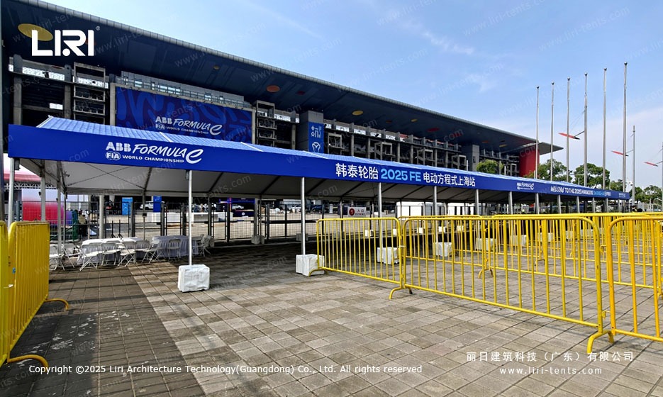 Hospitality lounge with white folding chairs under blue roof marquee at the ABB Formula E Shanghai E-Prix