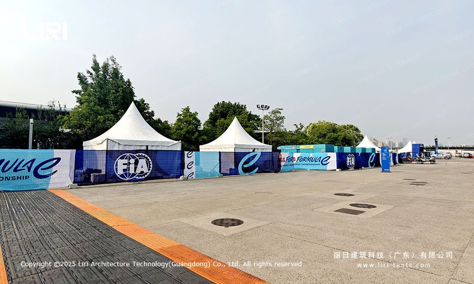 Multi-zone exterior wide shot showing pagoda tents along the race circuit with FIA Formula E branding
