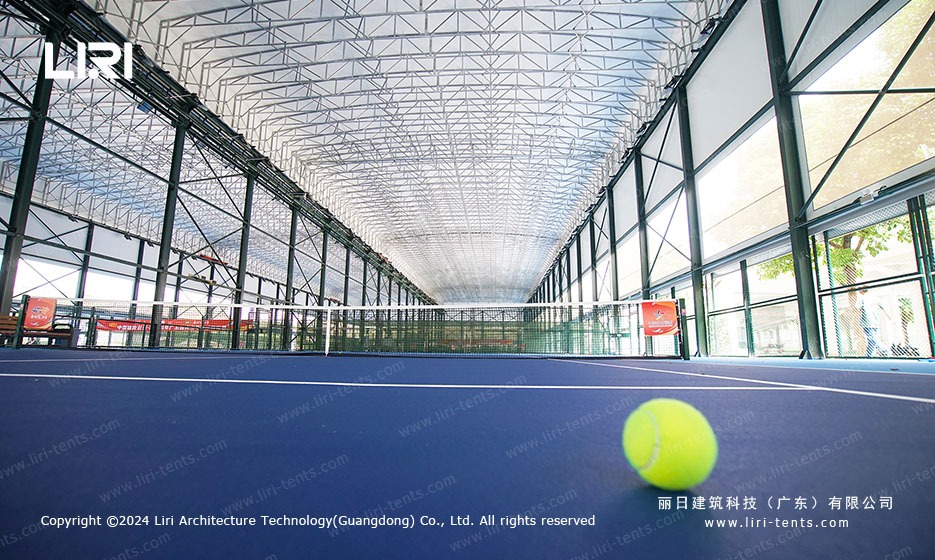 Net level view inside tennis marquee showing full court length