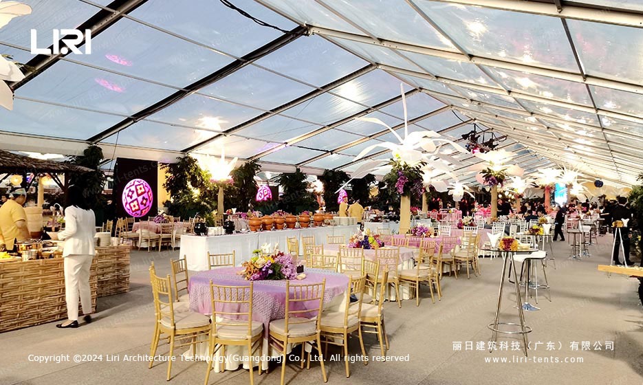Transparent event marquee tent at night showing interior lighting through PVC roof