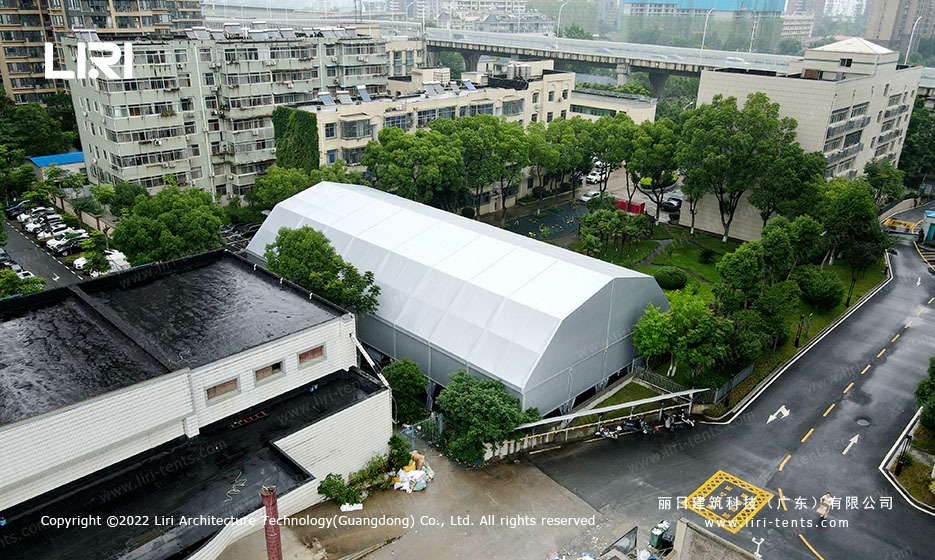 Aerial view of polygon tennis court marquee with arcum roof on a city sports facility