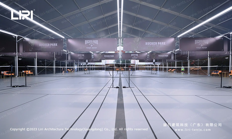 Badminton court center view showing suspended net system and LED lighting inside marquee