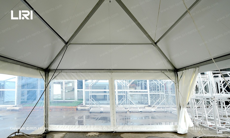 Inside pagoda tent showing aluminum frame and transparent wall panel