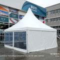 Pagoda gazebo with clear PVC sidewalls near showroom building