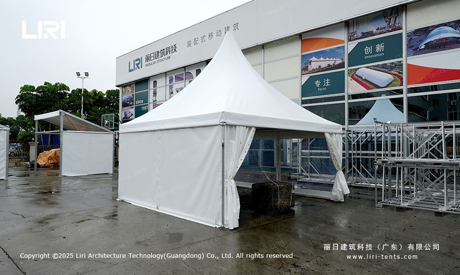 Concrete ballast blocks anchoring pagoda tent on hard surface