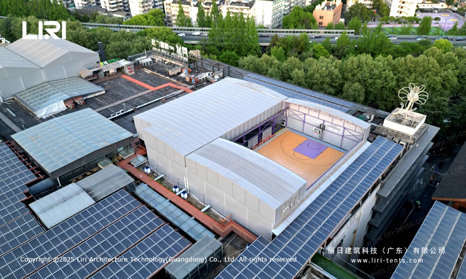 Purple gable twin peak marquee aerial drone view over rooftop basketball court next to solar panels