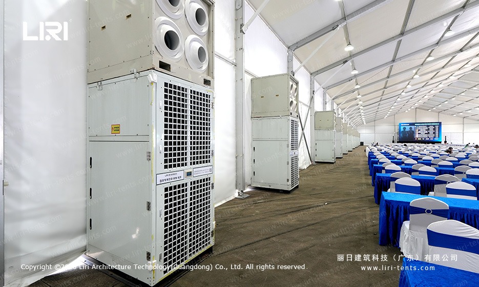 Inside the spectator lounge with HVAC units, banquet seating and a viewing screen