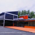 Exterior view of commercial sports hall marquee with bold orange and black facade