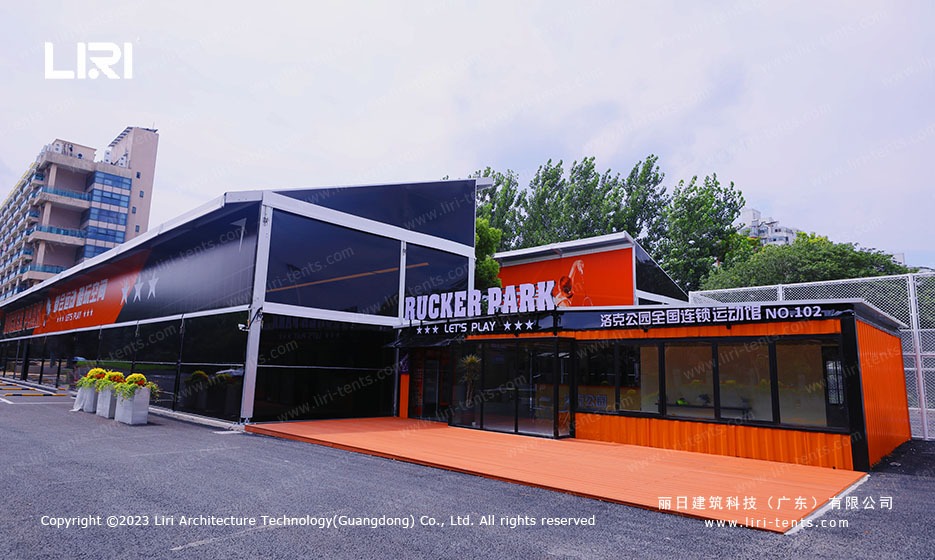 Exterior view of commercial sports hall marquee with bold orange and black facade