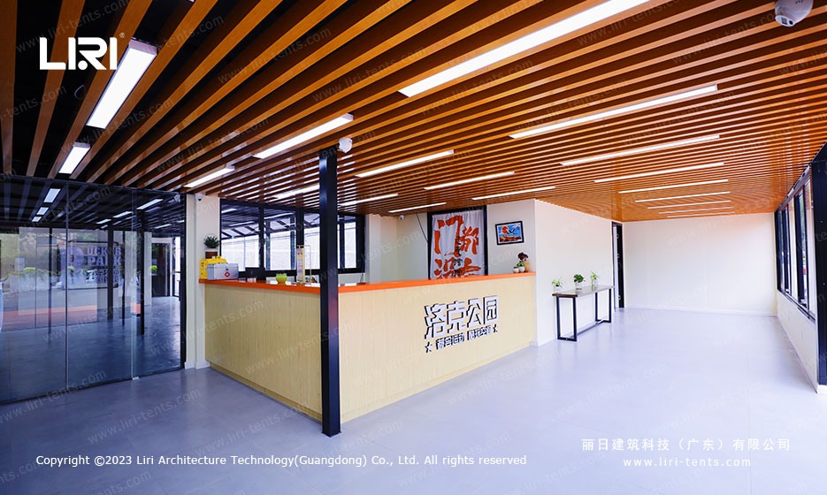 Reception lobby with slatted wood ceiling inside marquee sports hall