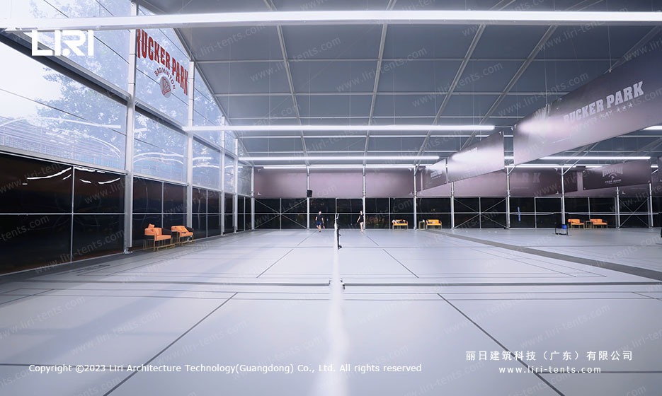 Transparent glass sidewall section of sports marquee with courts inside