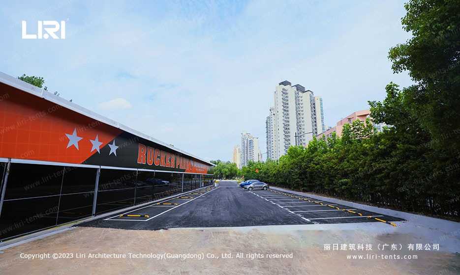 Wide exterior angle of sports marquee beside parking lot and city skyline