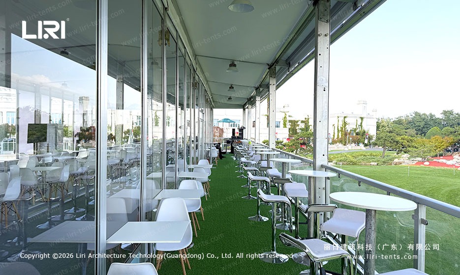Course-facing terrace with tables beside the glazed marquee